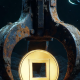 An industrial claw pulling a gold coin from the dark ocean floor, representing a crypto airdrop checker finding forgotten money safely.